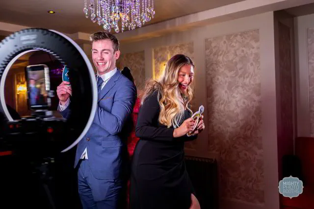 two people laughing and posing for a 360 photo booth in a wedding in austin texas