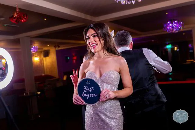 a bride and a groom posing for a photo in a 360 photo booth
