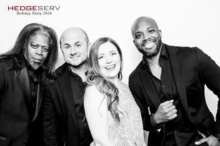 four people posing for a black and white photo booth in a corporate event