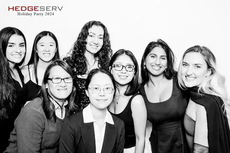 eight women posing for a black and white photo booth in a corporate event