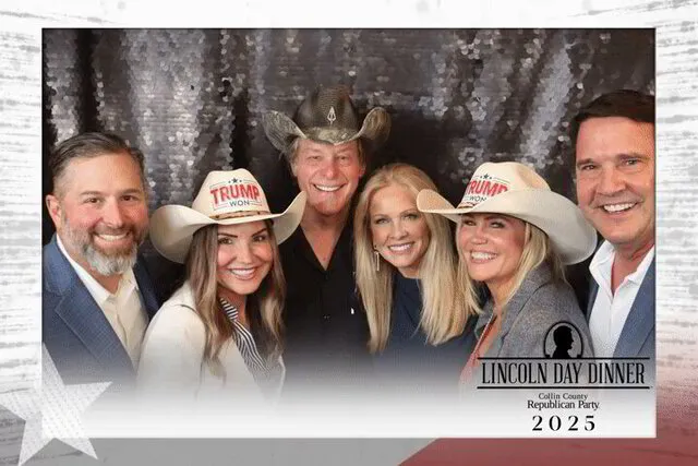 five people, three of them wearing branded hats, smiling for a photo portrait studio in a corporate event