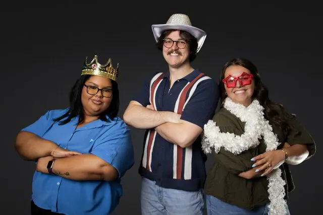 three people posing for a photo portrait studio while wearing themed props