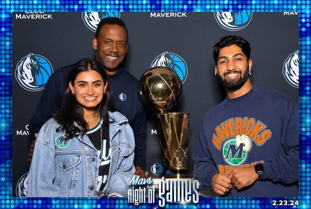 three people holding a trophy posing for a photo booth in a sports event 