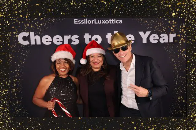 three people wearing hat props posing for a photo booth in a holiday corporate event