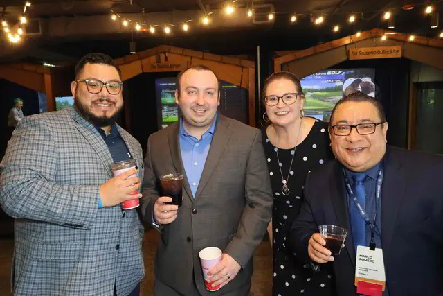 four people posing for a roaming photo booth in a corporate event