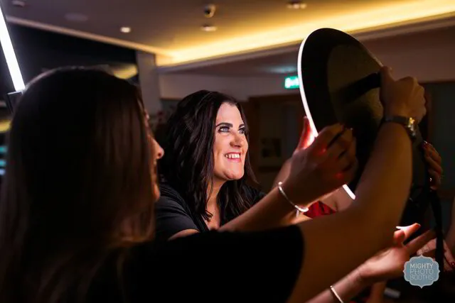 a woman smiling for a roaming photo booth in a party