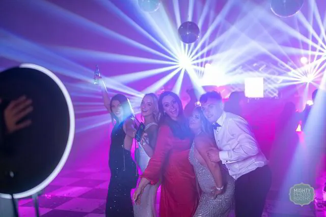 five people posing for a roaming photo booth in a party